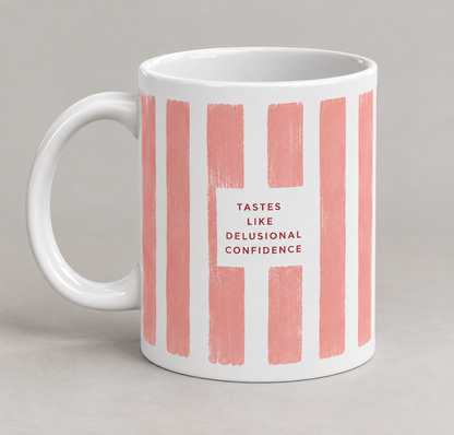 Tastes Like Delusional Confidence mug – white 11oz ceramic coffee mug with dusty pink stripes