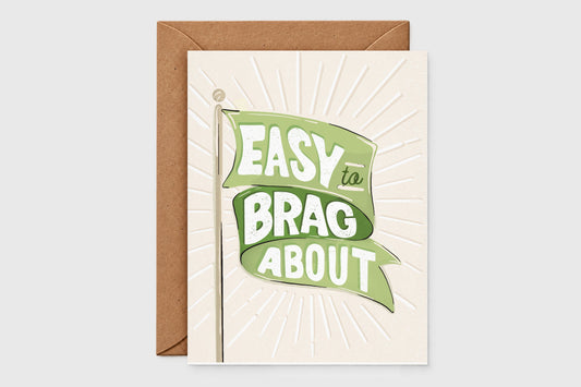 'Easy to Brag About' green flag card with a green banner over an embossed sunburst on cream