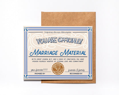Marriage Material engagement card designed as a vintage certificate with blue border and gold seal