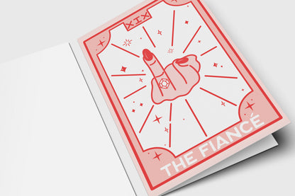 'The Fiancé' tarot-style engagement card in pink and red with a hand showing off a ring