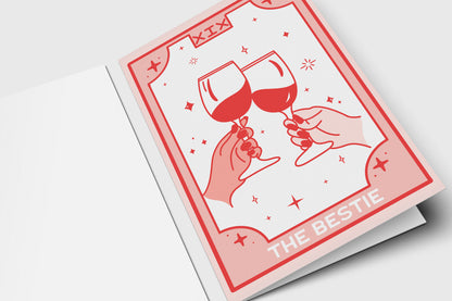 'The Bestie' tarot-style best friend card in pink and red with two hands clinking wine glasses