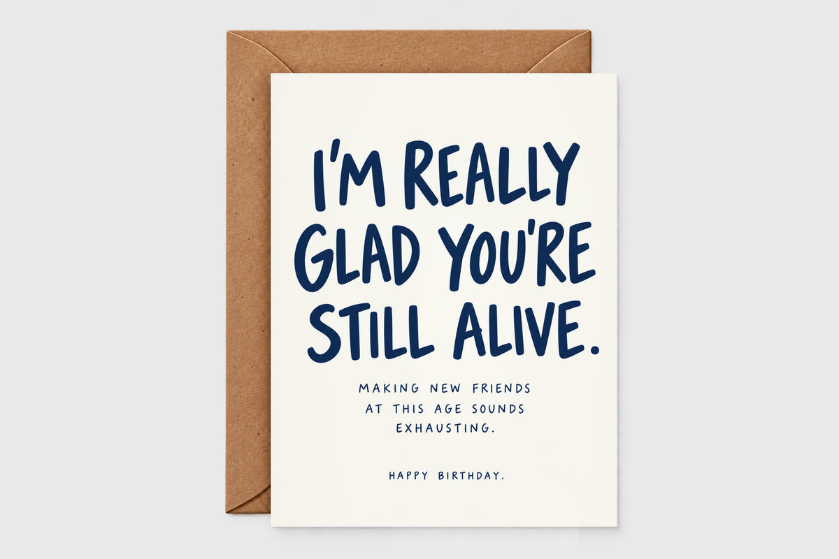 I'm Really Glad You're Still Alive funny birthday card in navy text on cream with kraft envelope