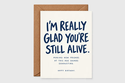 I'm Really Glad You're Still Alive funny birthday card in navy text on cream with kraft envelope