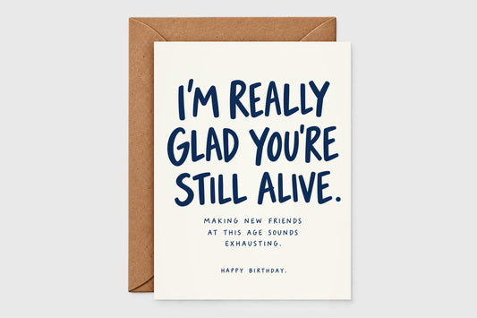 I'm Really Glad You're Still Alive funny birthday card in navy text on cream with kraft envelope