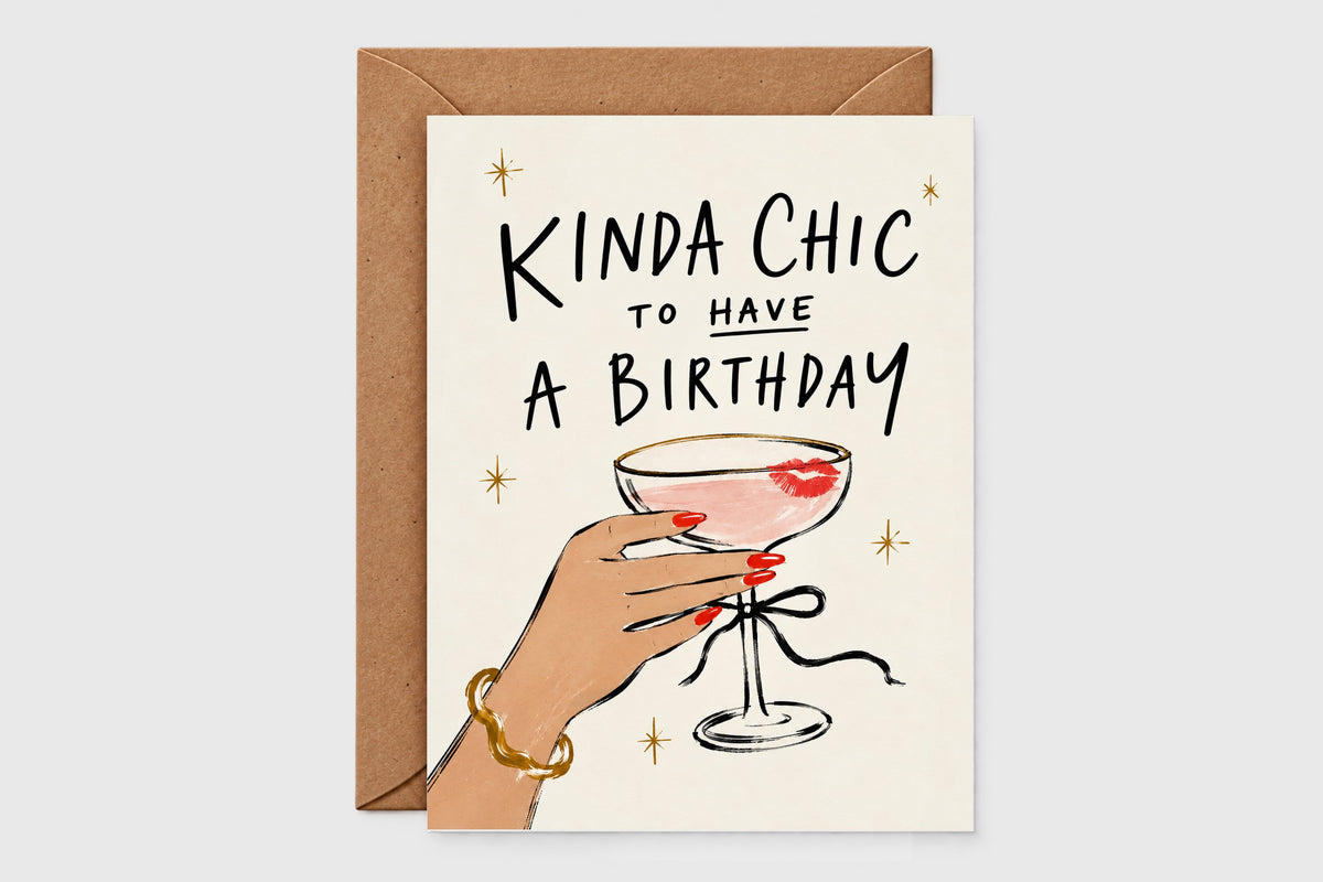 Kinda Chic to Have a Birthday card with a hand holding a coupe cocktail with a lipstick kiss, kraft envelope