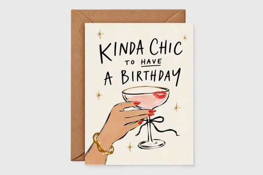 Kinda Chic to Have a Birthday card with a hand holding a coupe cocktail with a lipstick kiss, kraft envelope