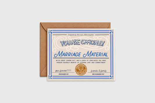 Marriage Material engagement card designed as a vintage certificate with blue border and gold seal