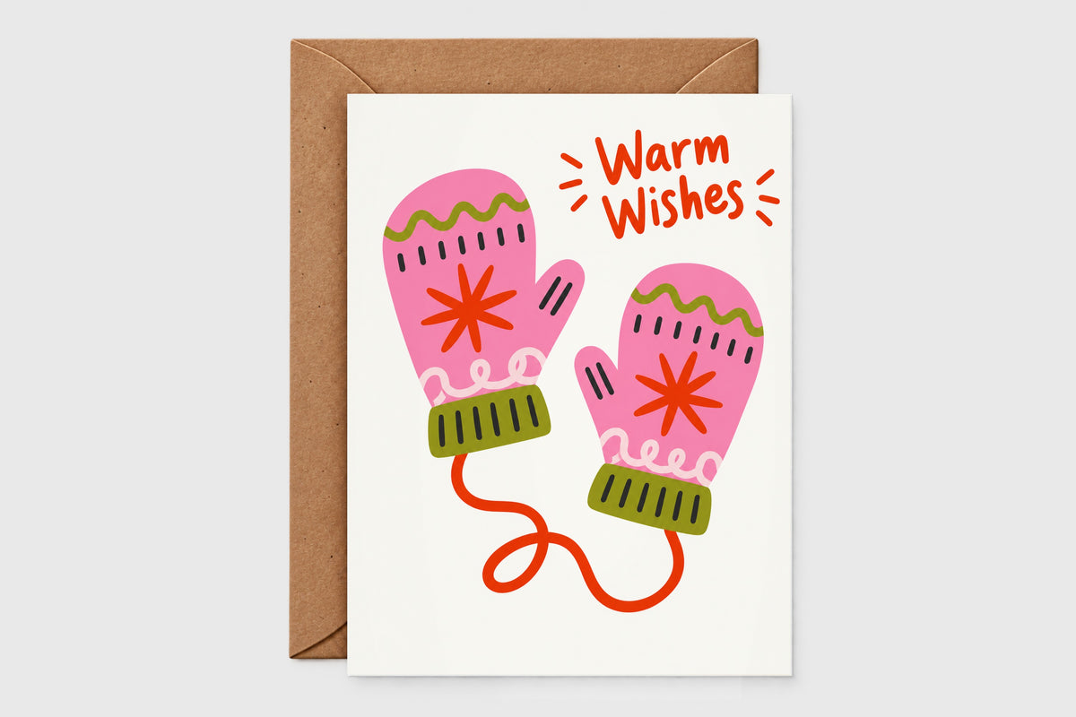 Warm Wishes holiday card with pink mittens connected by a red string on a cream background